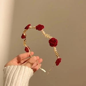 Detailed shot of vintage gold headband with red velvet roses and elegant white pearls
