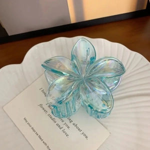 Pince à cheveux fleur de frangipanier bleue irisée avec finition holographique chic