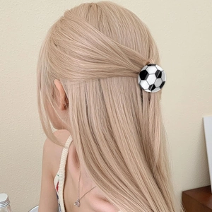 Detailed view of a soccer ball shaped hair claw clip styled on a woman's ponytail