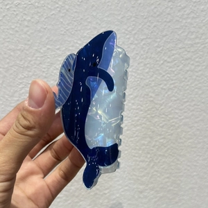Detailed view of a blue whale hair claw clip made of iridescent acetate material
