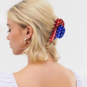 American flag shark hair claw clip and gold star earrings set on a model with blonde hair
