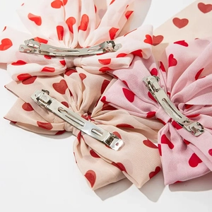Lot de trois barrettes nœuds en mousseline avec motifs cœurs rouges sur fond blanc