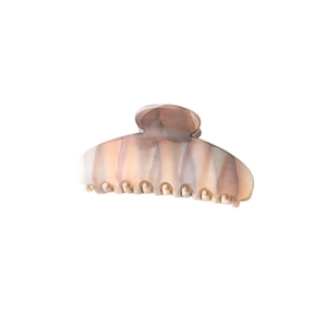 Close-up of the smooth beige marble texture and glossy finish on the shark hair clip
