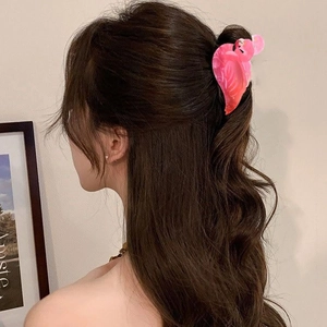Pink flamingo hair claw clip in marbled acetate shown on model for a side-view hairstyle