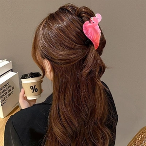 Pink flamingo hair claw clip in pearlescent acetate finish on wavy brown hair