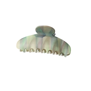 Detail view of large matte shark hair clip with green and grey marbled texture finish