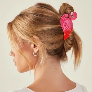 Detailed view of a pink flamingo hair claw clip holding a bun hairstyle securely