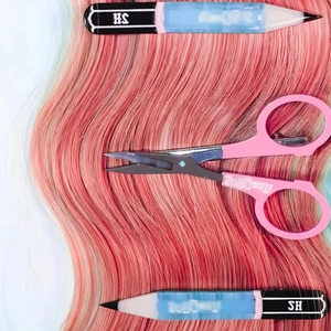 Creative pencil hair clips and pink handle scissors set on pink orange gradient wavy hair