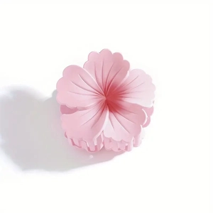 Close-up of pink flower hair claw clip with matte resin texture and smooth teeth edges