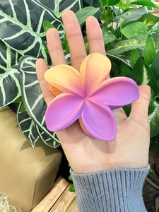 Dettaglio molletta per capelli a forma di plumeria opaca con sfumatura giallo-viola