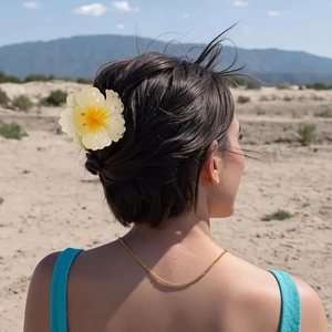 Detail of a tropical frangipani hair claw clip worn on model's dark brown hair