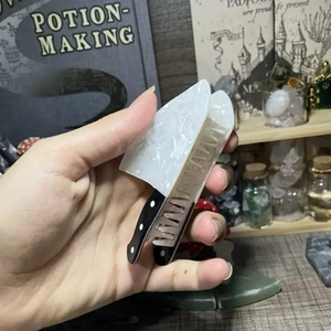 Punk-Stil Haarklammer aus Acryl im Küchenmesser-Design, handgehalten vor dunklem Hintergrund