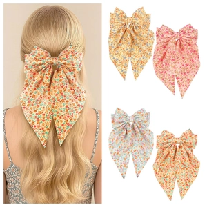 Détail des barrettes à fleurs avec de longs rubans déclinées en quatre coloris