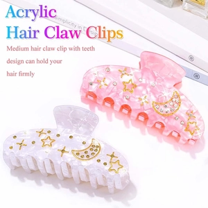 Detail of medium acrylic hair claws with marble texture and star moon rhinestone inlay