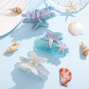 Detailed view of rhinestone starfish hair claws in blue, purple and silver gradient