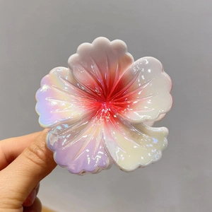 Makroaufnahme der Hibiskus-Haarklammer mit buntem Perlmutt-Farbverlauf und Harzstruktur