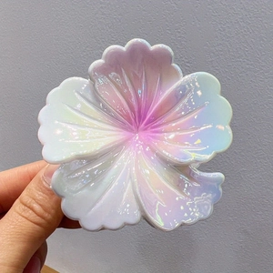 Detail der irisierenden Plumeria-Haarklammer mit perlmutthellen lila Farbverlauf