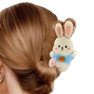 Detail of cute rabbit hair claw clip with orange carrot motif on high quality acetate material