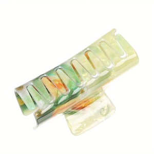 Translucent green hair claw clip with orange floral pattern and classic shark clip design