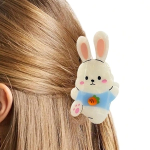 Close-up of a cute white rabbit hair claw with carrot motif worn on a ponytail