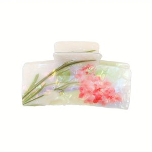 Detailed view of pearlescent acetate hair claw clip with pink floral prints and green leaves