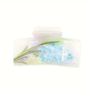 Detailed view of floral hair claw clip with blue and green painted botanical patterns