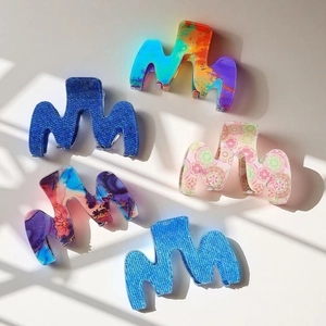 Vue détaillée de cinq pinces à cheveux en forme de M aux motifs arc-en-ciel et bohèmes