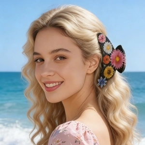 Detail of large black hair claw clip with colorful resin flowers worn on the beach