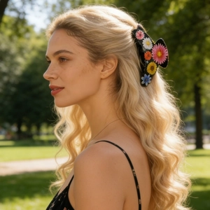 Floral hair claw clip with colorful daisy patterns on black base worn by a model