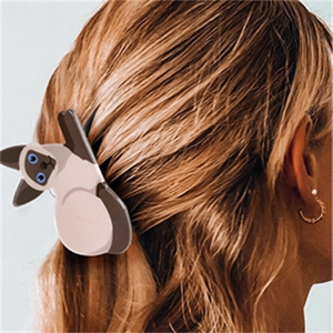 Détail d'une pince à cheveux chat siamois créative sur des cheveux blonds