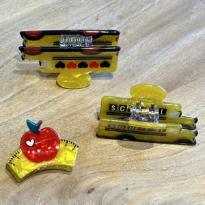 Detail view of cartoon school bus and apple ruler hair clips with yellow acrylic finish