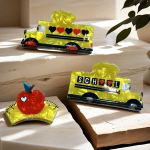 Cartoon school bus and red apple acetate hair claws set on stone steps with sunlight