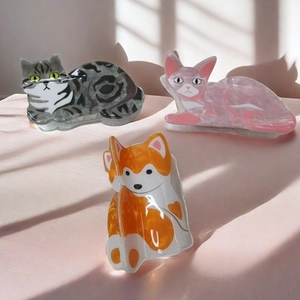 Trois pinces à cheveux chat mignonnes en gris, rose et orange sur fond rose élégant