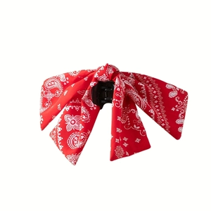 Detail of red paisley pattern bow hair claw clip showing fabric texture and structure