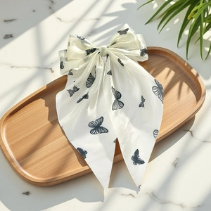 Fermaglio per capelli a fiocco bianco con stampa di farfalle e nastri su vassoio in legno
