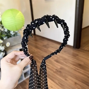 Détail du serre-tête à pois noirs avec dents antidérapantes et longs rubans décoratifs
