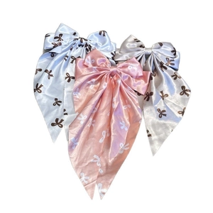 Three-piece set of satin bow hair clips with long streamers and subtle ribbon prints