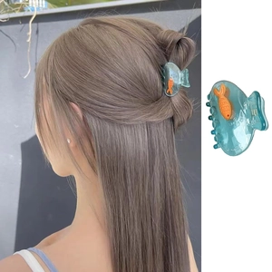 Détail de la pince à cheveux bleue translucide avec un motif de petit poisson orange