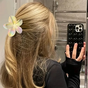 Iridescent plumeria hair claw clip with gradient pearl finish on long blonde hair