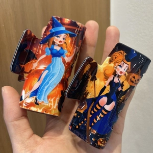 Dettagli di due fermagli per capelli Halloween con stampe vintage di strega e zucca