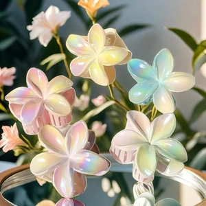 Close-up of iridescent plumeria hair claws with pearl finish and colorful gradients