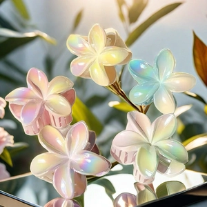 Iridescent frangipani hair claws set in macro view with colorful pearlescent finish