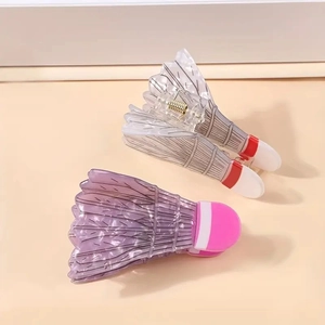 Vue détaillée des pinces à cheveux volant montrant la texture des plumes et le ressort