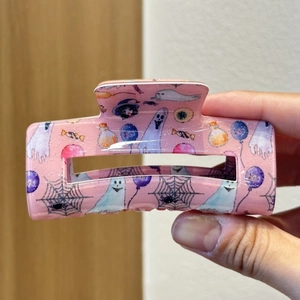 Pink glitter Halloween claw clip featuring ghosts, spiderwebs and boo balloon patterns