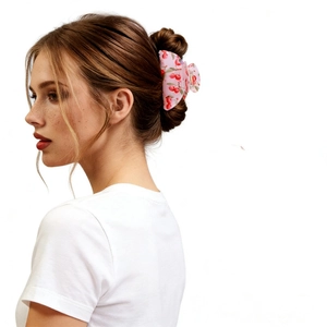 Close-up of cherry print hair claw clip securing a bun on a woman's brown hair