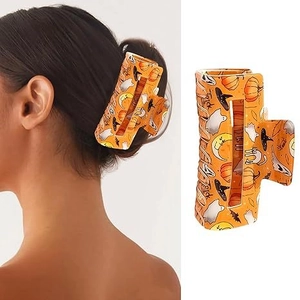 Dettaglio della molletta per capelli a zucca di Halloween con motivi festivi e styling