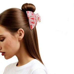 Close-up of pink translucent cherry print hair claw clip worn on hair with metal spring