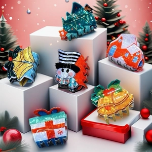 Close-up of 6 Christmas themed hair clips with snowman and tree shapes on festive display