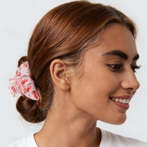 Detail view of large light pink hair claw clip with cherry print for ponytail styling
