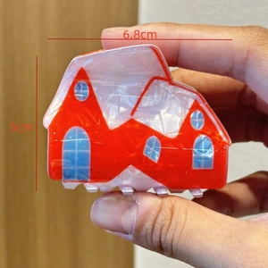 Detailed view of a red house-shaped hair claw clip with dimensions 6.8cm by 5cm